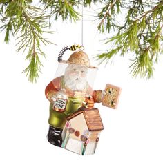 a christmas ornament hanging from a tree with a house and bird on it