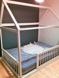 a bed with a canopy over it in a room that has hardwood floors and walls