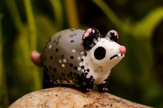 a small toy mouse sitting on top of a rock