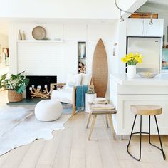 a living room filled with furniture and a fire place next to a white counter top