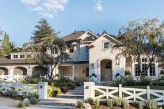 a house with white picket fence and trees