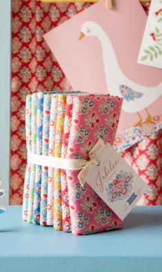 a stack of colorful papers sitting on top of a blue table next to a bird