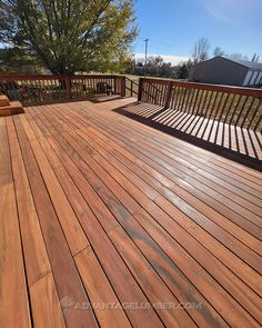 a wooden deck with benches on it and trees in the backgroung area