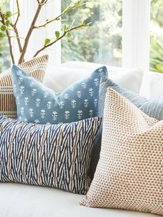 pillows on a couch in front of a window