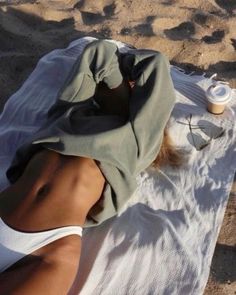 a woman laying on top of a white towel