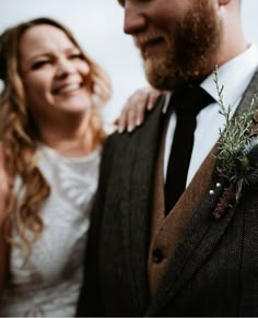 a man in a suit and tie standing next to a woman