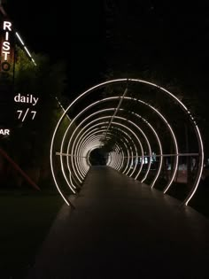 a long tunnel that is lit up at night with the lights on it's sides