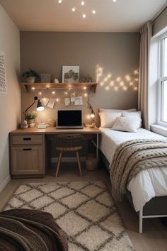 a bed room with a neatly made bed and a laptop on a desk next to a window