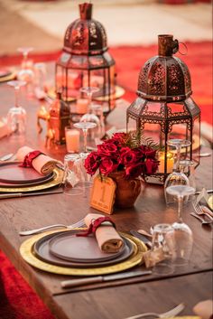 a wooden table topped with lots of place settings