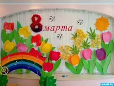 there is a colorful display on the wall with flowers and rainbows in front of it