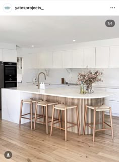 an image of a kitchen setting with stools on the counter and island in the middle