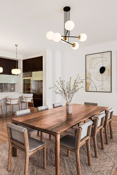 a dining room table surrounded by chairs and lights