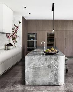 a kitchen with marble counter tops and an island in front of the stove top oven