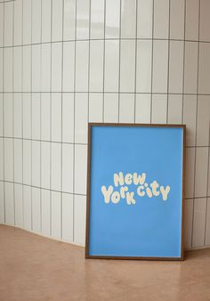 a blue poster with the words new york on it in front of a tiled wall