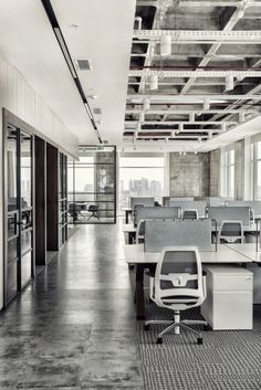 an empty office with lots of desks and chairs in black and white photo,