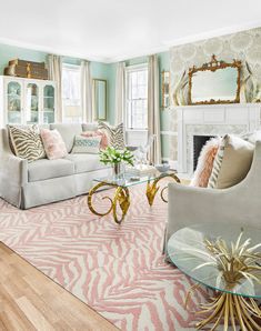 a living room filled with furniture and a fire place in front of a mirror on the wall