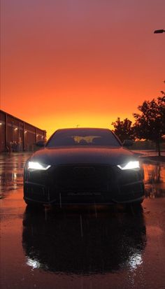 a black car is parked in the rain