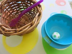 a basket and bowl sitting on top of a table next to each other with plastic spoons in it