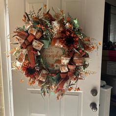 a wreath is hanging on the front door with autumn decorations around it and an i love pumpkin sign