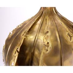 an ornate gold vase is shown against a white background and has holes in the middle