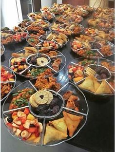 a table filled with lots of different types of food on it's trays