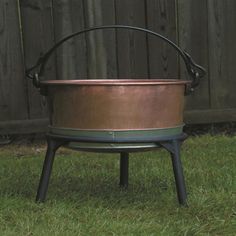 a large metal pot sitting on top of green grass