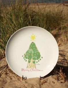 a plate with a christmas tree on it sitting in the sand