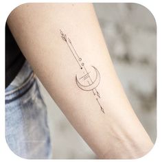 a woman's arm with an arrow and crescent tattoo on the left inner arm