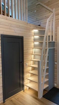 there is a staircase leading up to the second floor in this house with wood paneling and white painted walls