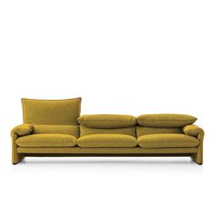 a yellow couch with two pillows on the back and one pillow on the side, in front of a white background