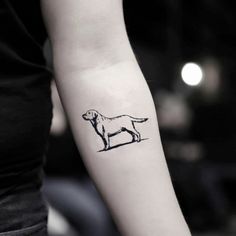 a black and white photo of a dog tattoo on the left arm, with an outline of a dog