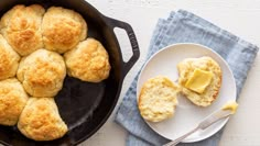 biscuits and butter on a plate next to a skillet with some butter in it