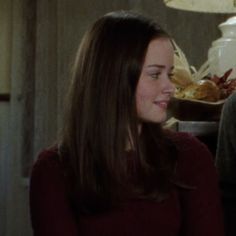 a man and woman sitting next to each other in front of a table with food on it