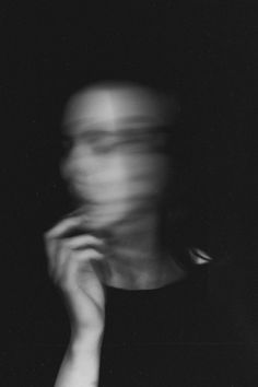 a blurry image of a woman's face with her hands in the air