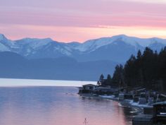 a lake with mountains in the background at sunset