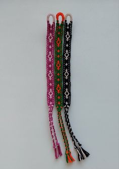 three different colored lanyards with tassels on them