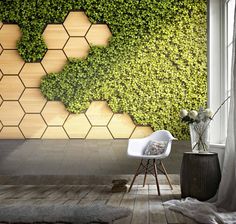 a living room with a wall covered in green plants and hexagonal tiles on the wall