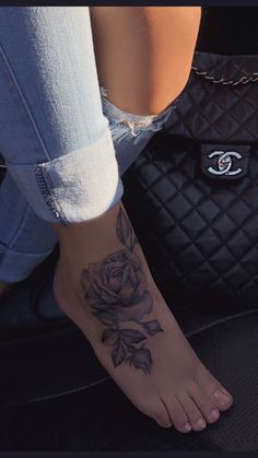 a woman's foot with a rose tattoo on it