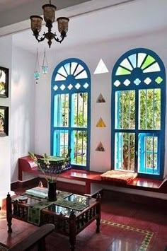 a living room filled with lots of windows next to a table and two couches