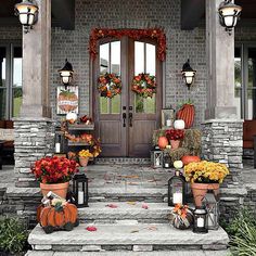 the front door of a home with pumpkins and flowers