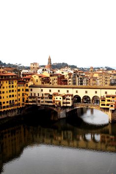 a bridge over a river with buildings in the background