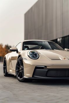 a white porsche sports car parked in front of a building