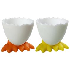 two egg cups sitting side by side on top of each other, one with an orange beak