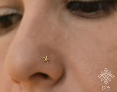 a woman's nose has a tiny gold star on it