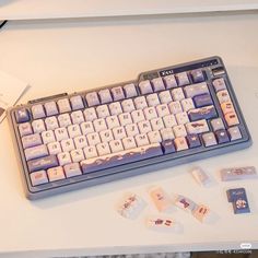 a computer keyboard sitting on top of a desk next to some small pieces of paper