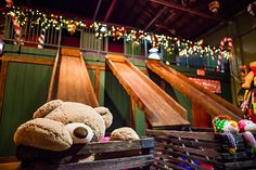 a stuffed teddy bear sitting on top of a wooden crate in front of christmas lights