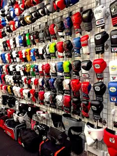 many different types of boxing gloves hanging on the wall