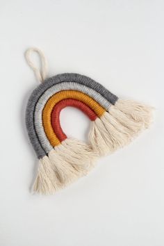 an ornament made out of yarn and tassels on a white background