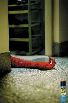 a red spider man laying on the floor next to a can