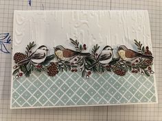 a card with birds and pine cones on it